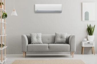 Split unit airco in huis aan de muur boven de bank.